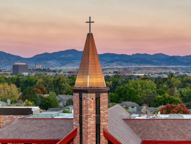 Beautiful view of Armstrong Center's chapel steeple with mountains in the distance.